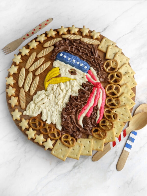 Finished eagle board with buttercream, crackers, and festive toppings.