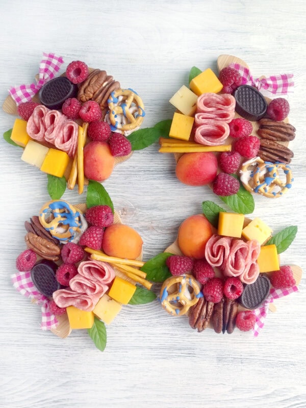 Top view of four colorful mini charcuterie boards arranged in a square.