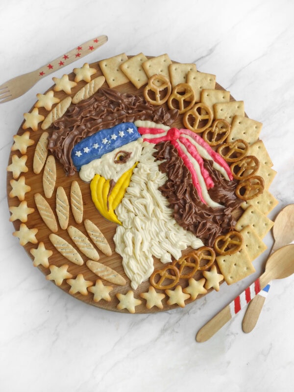 Full view of decorated patriotic buttercream board with utensils.
