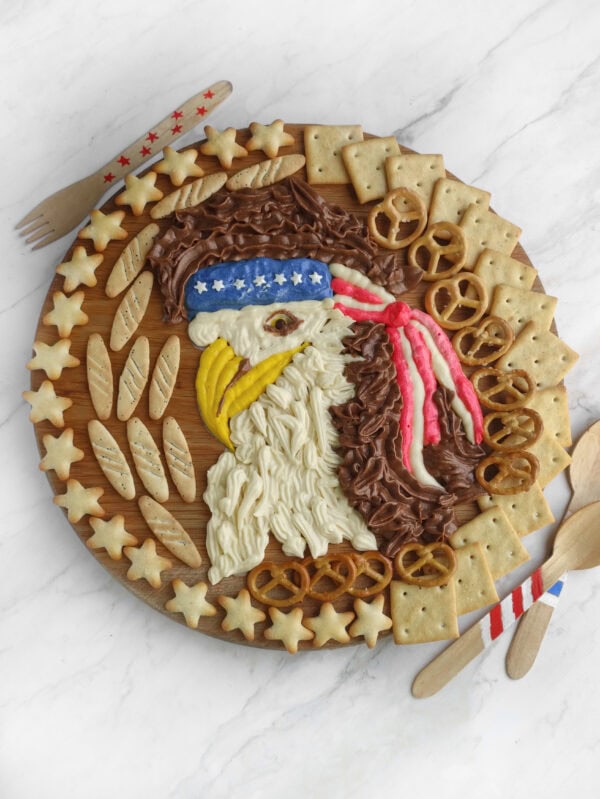 Decorated buttercream board with eagle and star-shaped crackers.