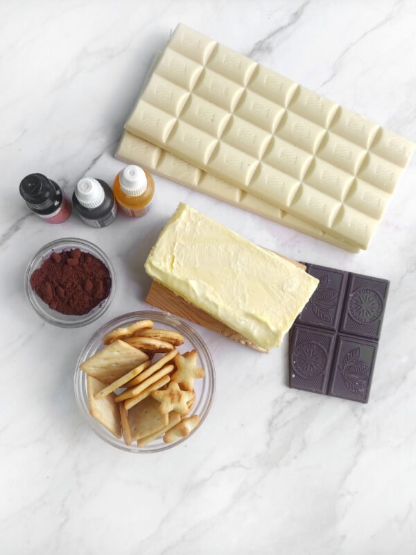 Ingredients including white chocolate, butter, cocoa, crackers, and food coloring.