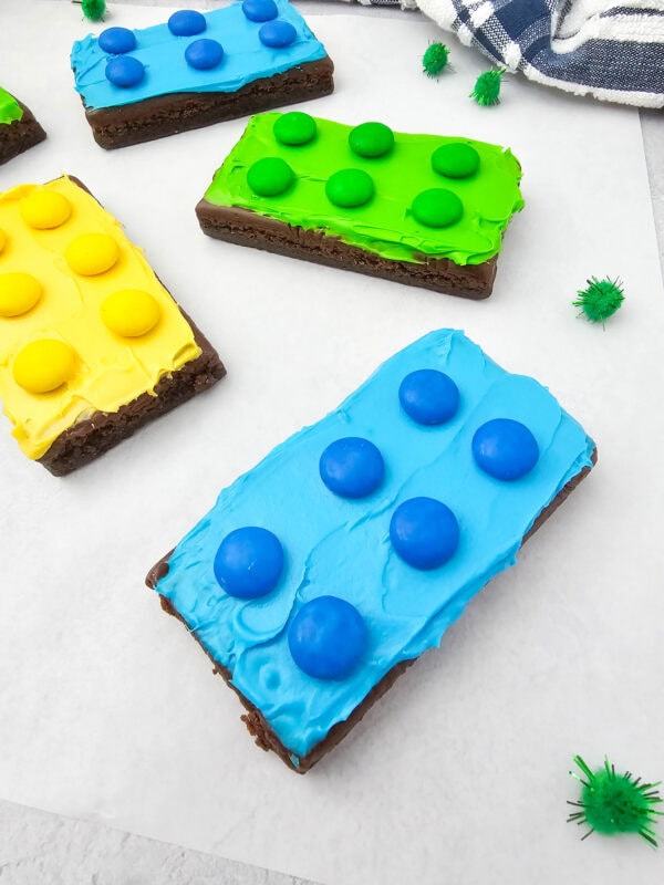 Close-up of LEGO brownies with bright frosting and matching candy pieces resembling LEGO bricks