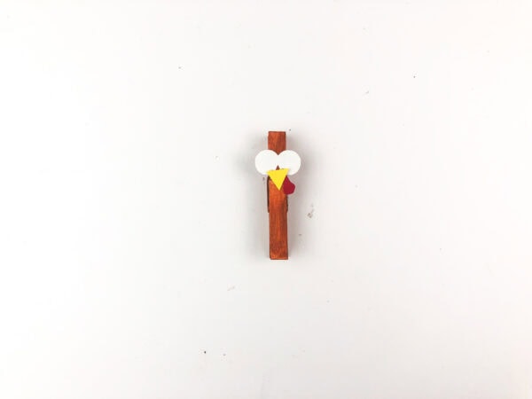 Clothespin with glued paper eyes, beak, and wattle.