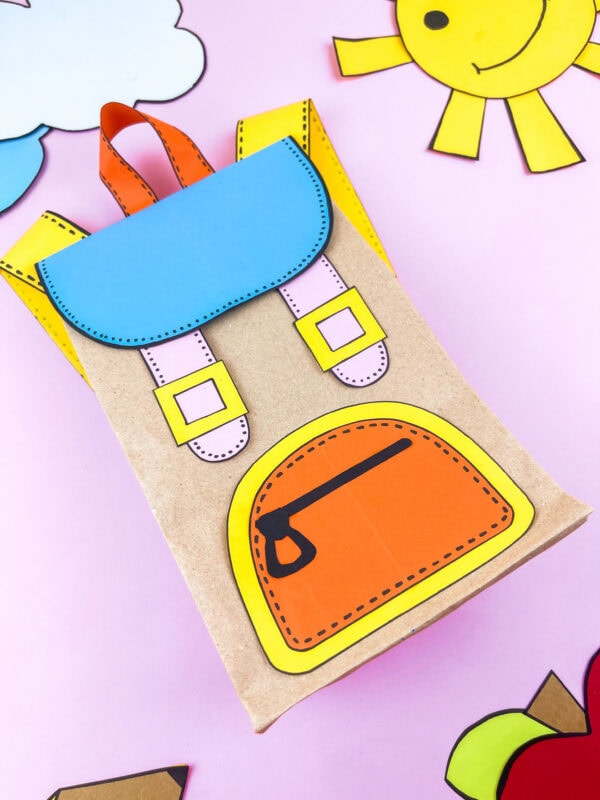 Finished backpack craft angled on a pink background with decorations