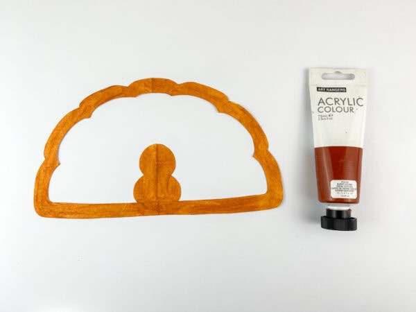 Paper outline painted orange with acrylic paint tube.