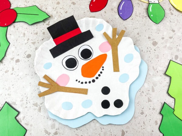 Melted snowman craft on table with holiday decorations.