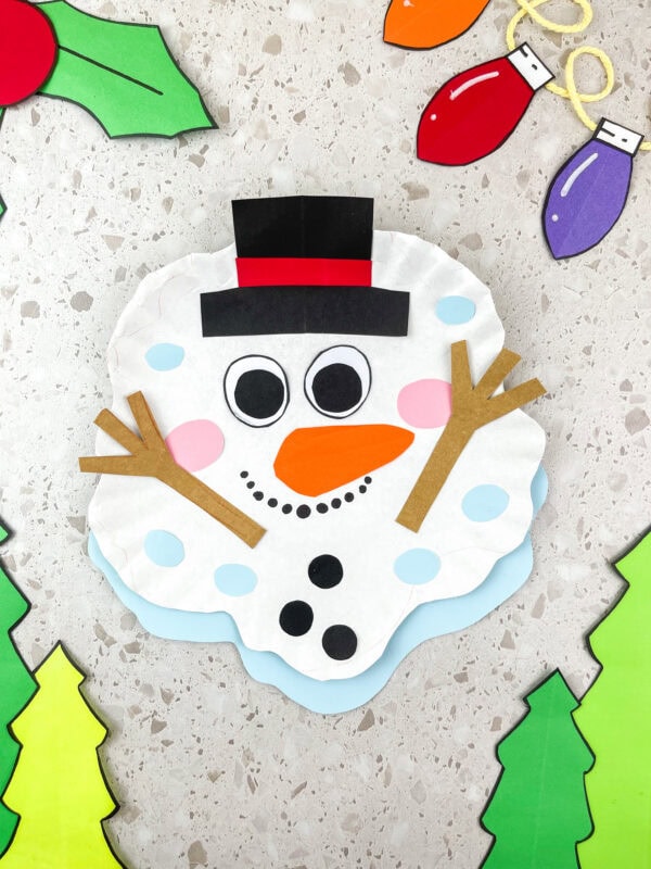 Melted snowman paper plate craft decorated with hat, arms, and buttons