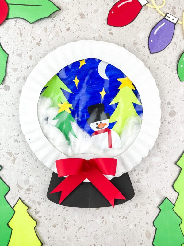 Completed snow globe craft with bow and decorations around