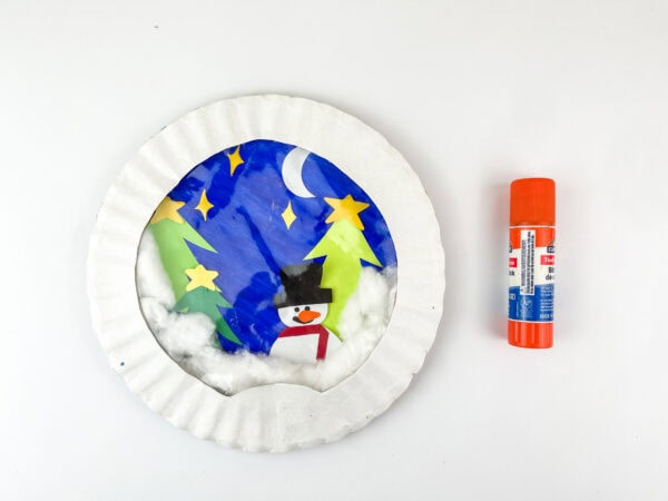 Snow globe craft with snowman inside and glue stick beside