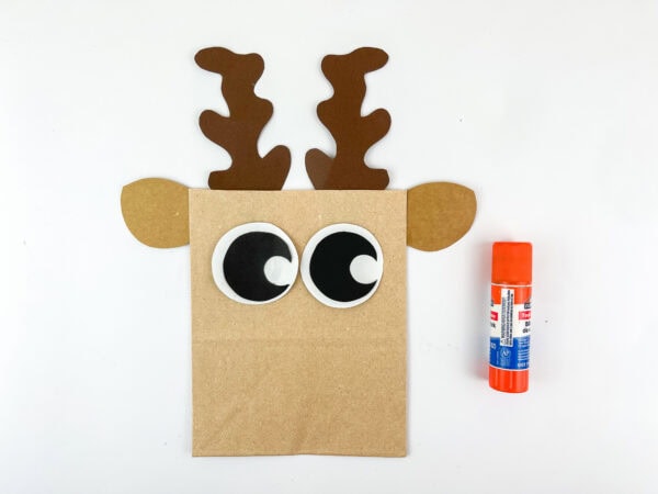 Paper bag with antlers, ears, and large eyes glued on