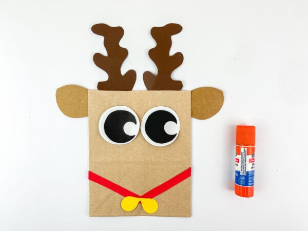 Paper bag reindeer with red strips and yellow bow added