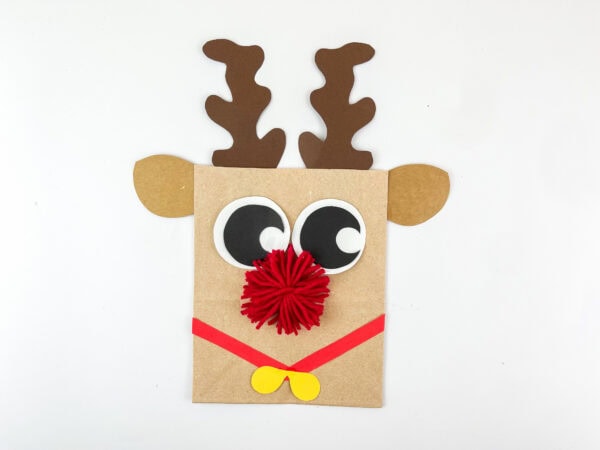 Finished reindeer paper bag craft with antlers, eyes, bow, and red nose