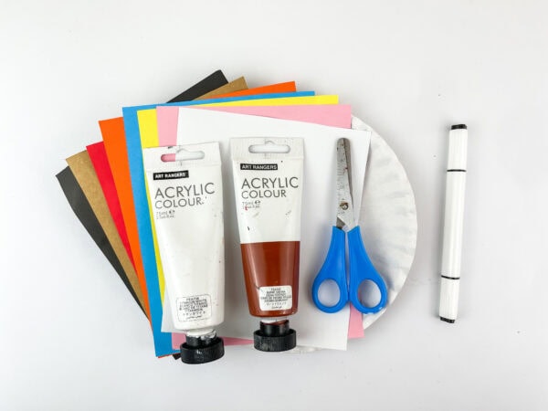 Craft supplies including acrylic paint, scissors, paper, plate, and marker