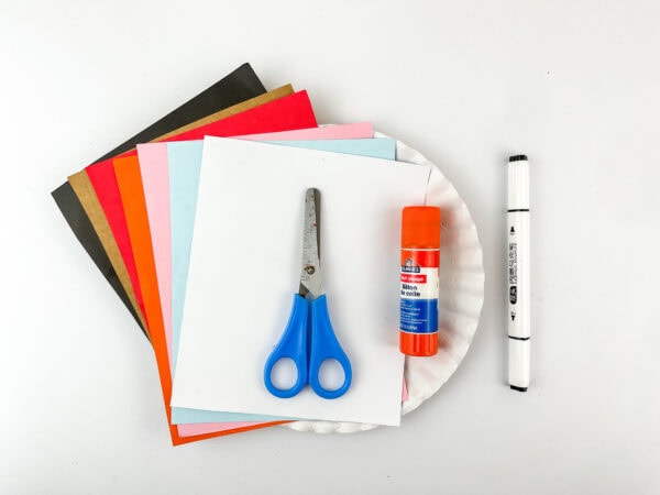 Craft supplies including paper, scissors, glue stick, and marker.