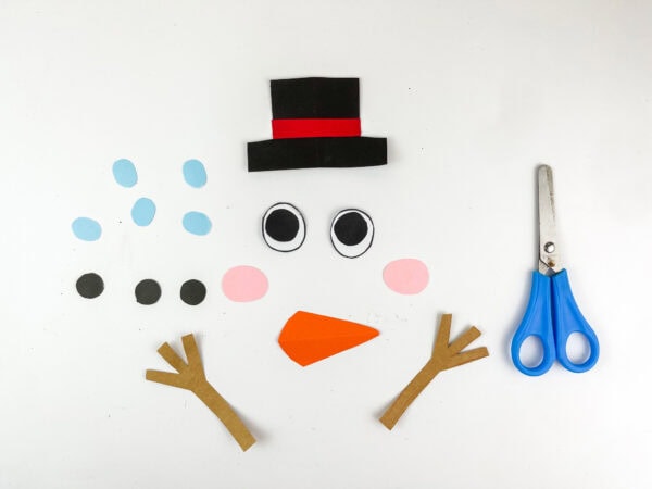 Cut out snowman parts including hat, eyes, nose, cheeks, arms, and dots.