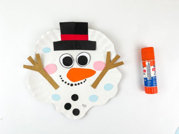 Melted snowman face assembled with hat, eyes, nose, and arms.