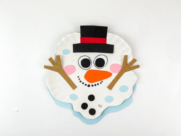 Finished melted snowman craft with arms raised.