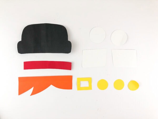 Cut paper shapes for pilgrim boy craft including hat, hair, buttons, and collar
