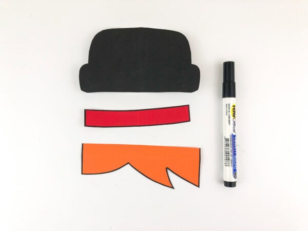 Black hat, red band, and orange hair cutouts with marker.