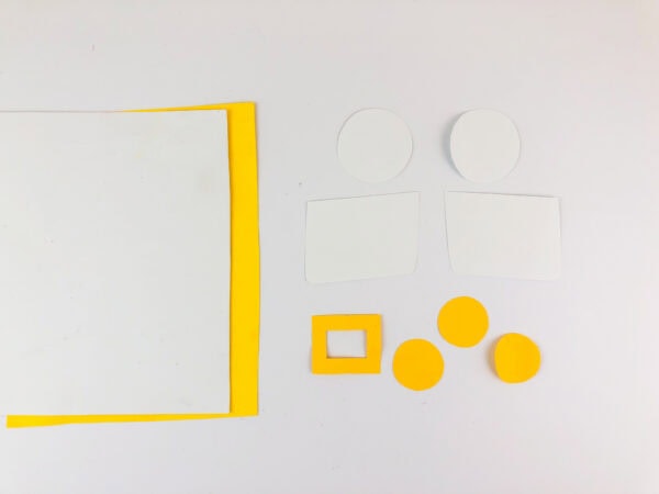 Cut-out paper shapes including circles, rectangles, and a square frame.