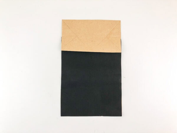 Brown paper bag with black paper glued on.