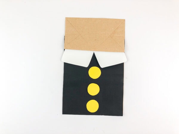 Paper bag with collar and three yellow buttons.