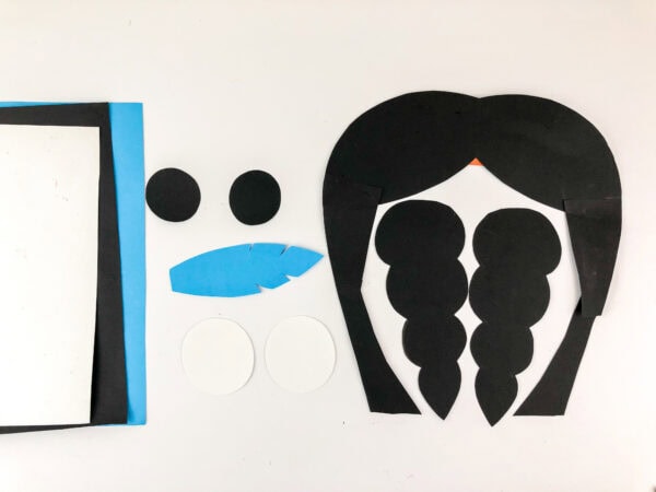 Cut-out hair, braids, eyes, and blue feather.
