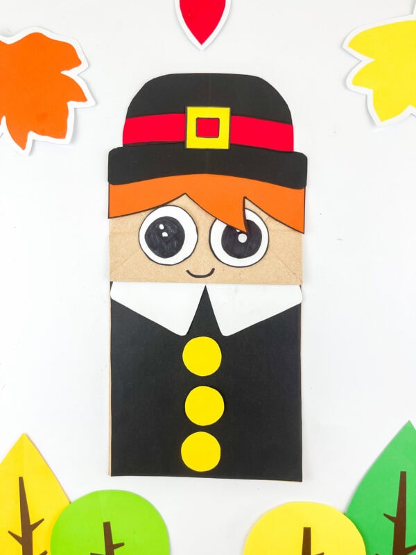 Pilgrim boy paper bag puppet with black outfit and yellow buttons