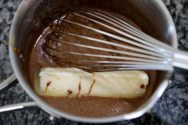 Butter melting into spiced mixture with whisk