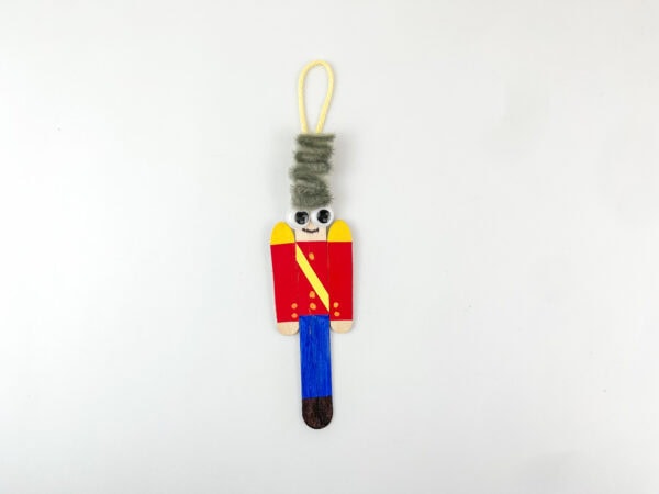 Nutcracker popsicle stick ornament with hanging loop.