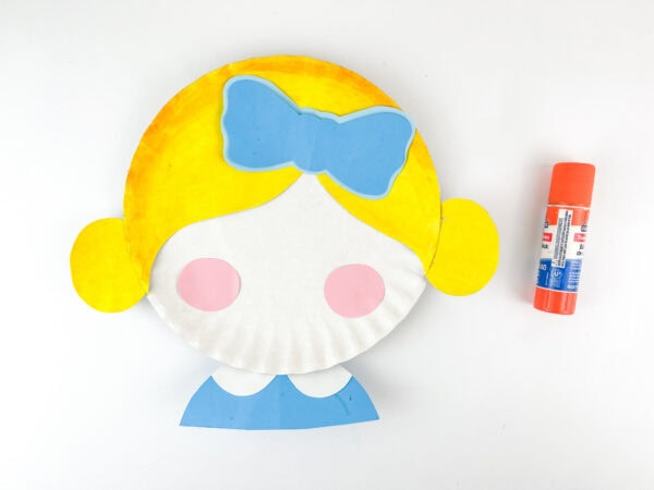 Clara paper plate craft with pink circle cheeks and blue bow.