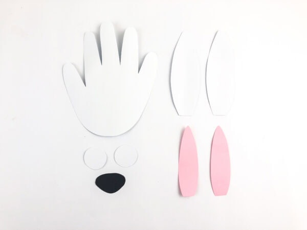 Cut-out shapes for the arctic hare craft, including handprint body and ears.