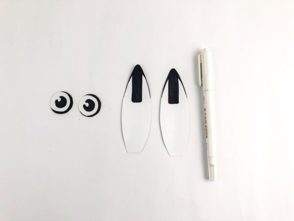 Drawn black ear tips and completed paper eyes for the hare craft.