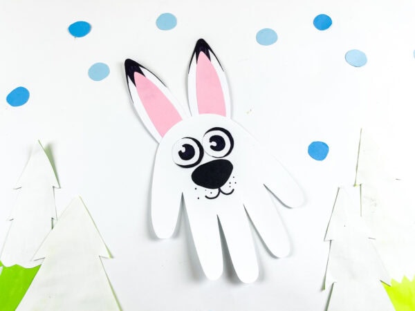 Handprint arctic hare craft displayed with blue paper snowdrops.