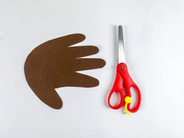 Brown handprint cutout next to scissors.