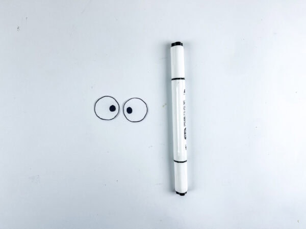 Marker next to two drawn eyes.