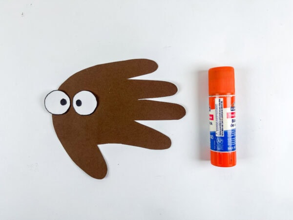 Eyes glued onto brown handprint shape.