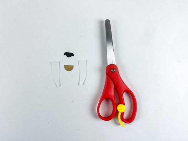Cutout tusks, nose, and mouth pieces next to scissors.

