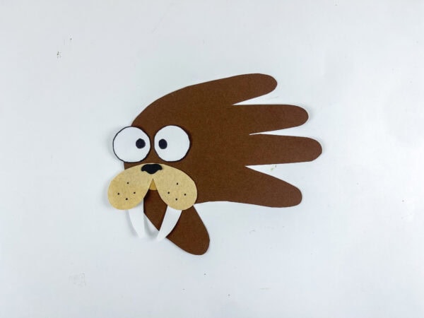 Completed walrus handprint craft shown on a plain background.