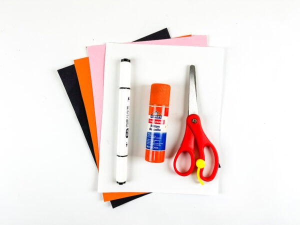 Craft supplies including paper, glue stick, marker, and scissors.