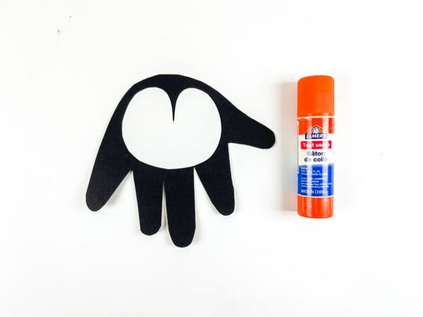 Penguin body with glued white face piece and glue stick.
