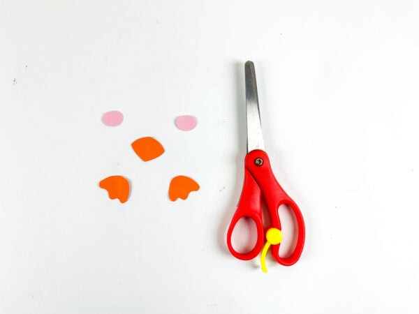 Cut pieces for penguin cheeks, nose, and feet with scissors.