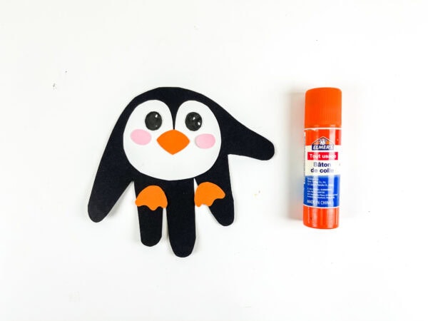 Completed penguin handprint craft with glued face and feet.