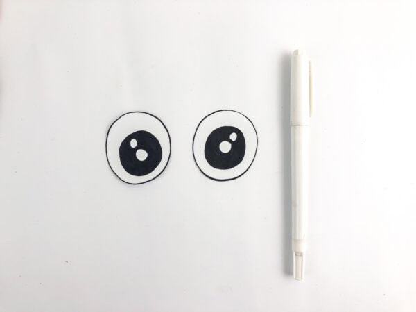 Drawn unicorn eyes beside a white marker.