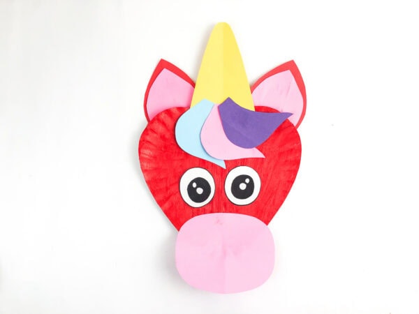 Unicorn paper plate craft with eyes attached.