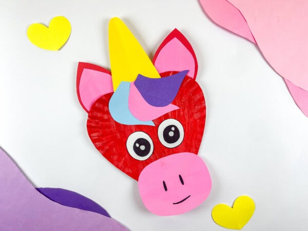Unicorn paper plate craft displayed with paper hearts.