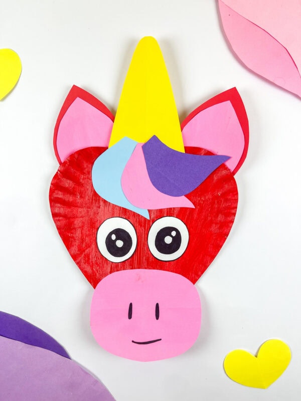 Vertical view of finished unicorn paper plate craft with hearts.