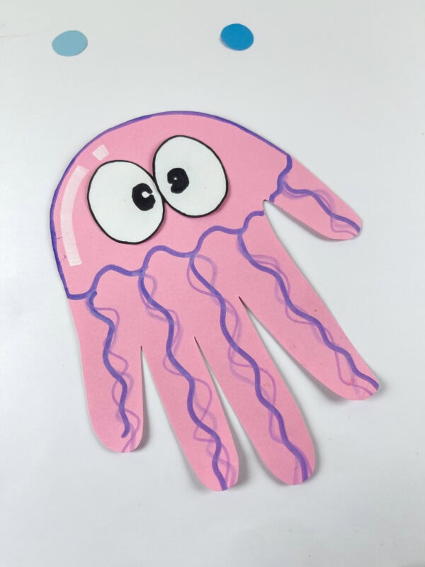 Pink jellyfish handprint paper craft on white background
