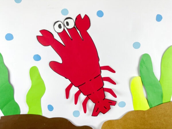 Finished lobster handprint paper craft on ocean background