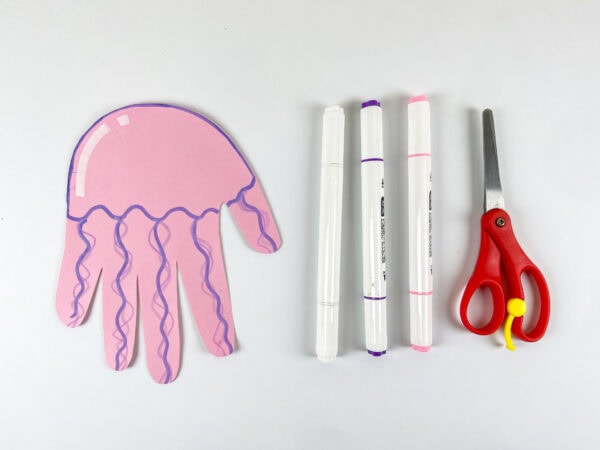 Cut pink jellyfish handprint with markers and scissors